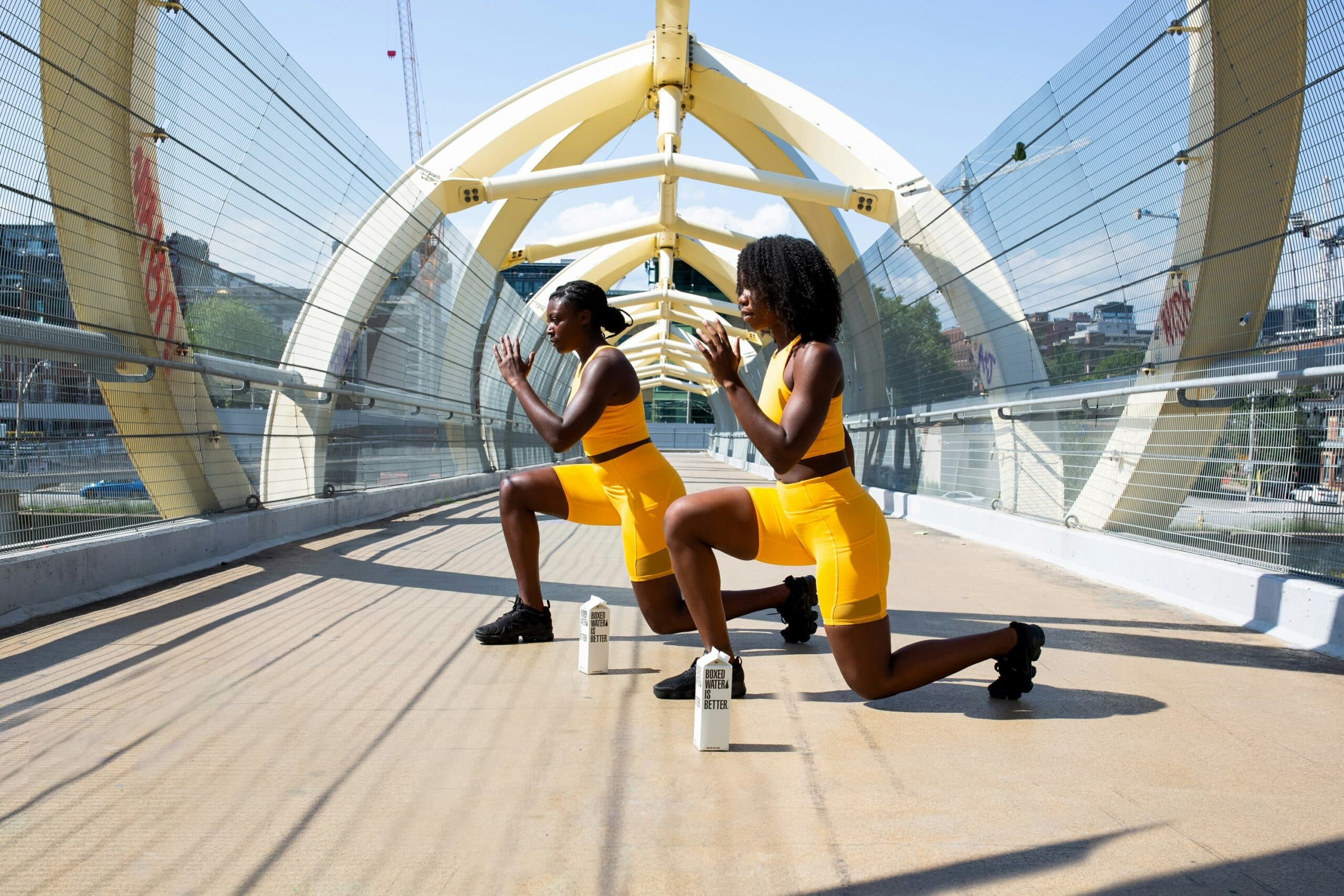 two women working out under the sun with water