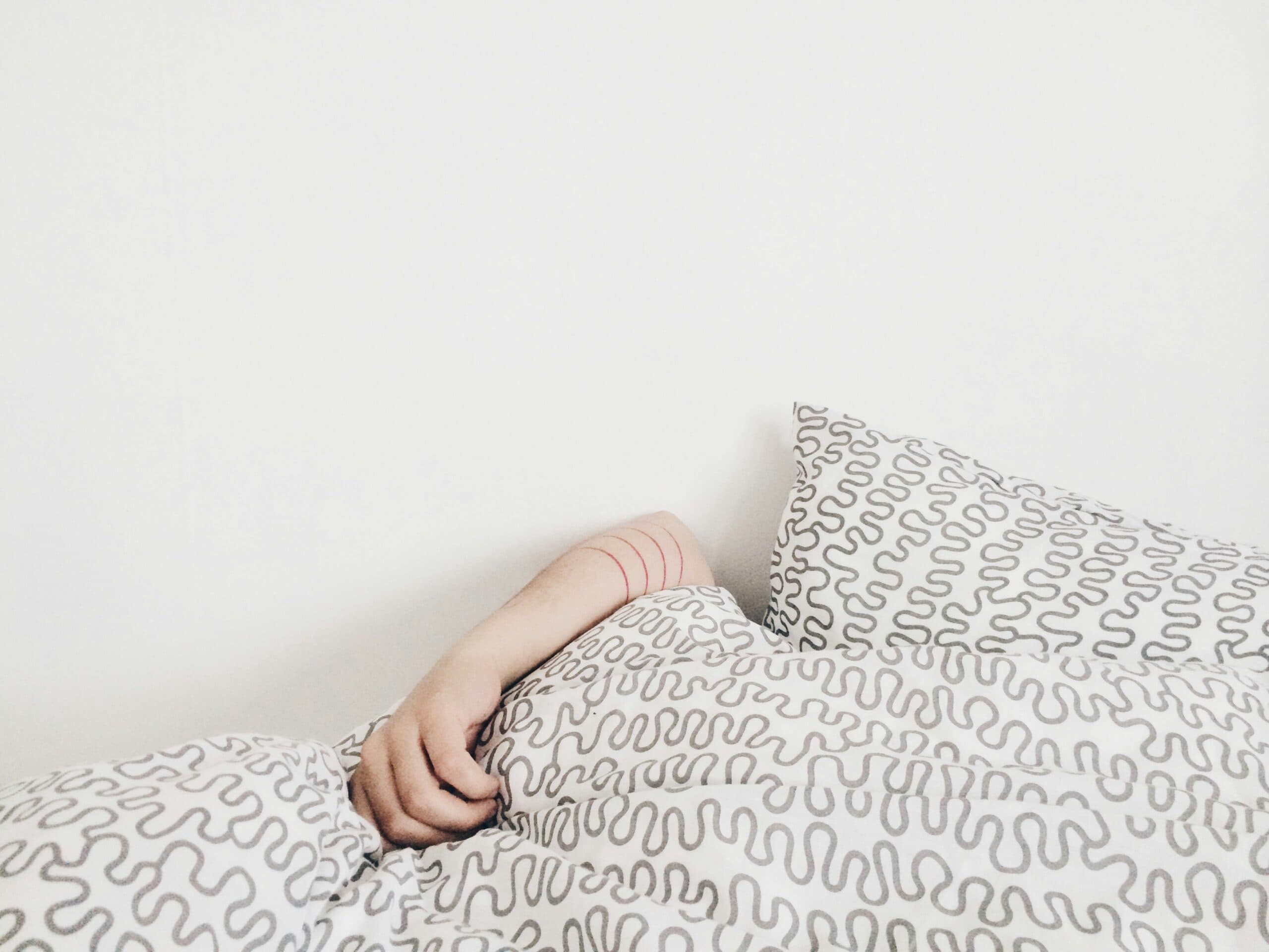 girl sleeping under the covers in an aircon room