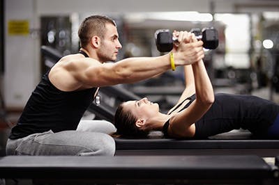 Personal trainer helps client
